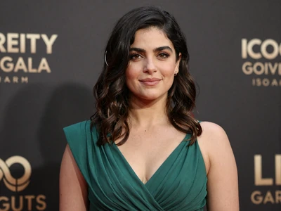Latina woman in an elegant emerald dress at a charity gala event