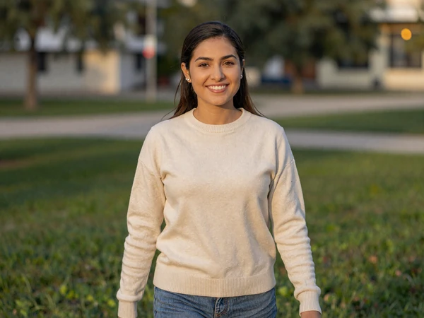 Female LPN enjoying a weekend walk in a park wearing casual cream sweater